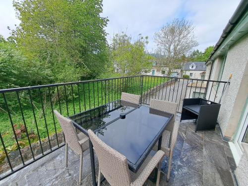 a patio with a table and chairs on a balcony at Loch Ness Balcony Apartment in Drumnadrochit