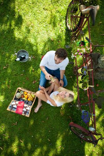 a man and a woman sitting in the grass at Boutiquehotel Liebesglück - adults only in Winterberg