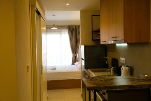 a room with a kitchen and a bedroom with a bed at BluMango Resort in Ierissos