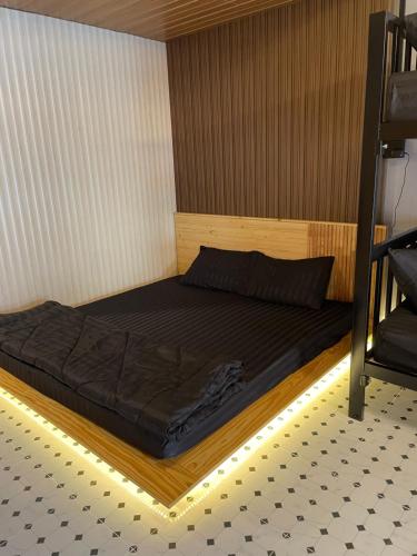 ベトンにあるPatchara Homeの木製のベッドフレームが備わるドミトリールームのベッド1台分です。