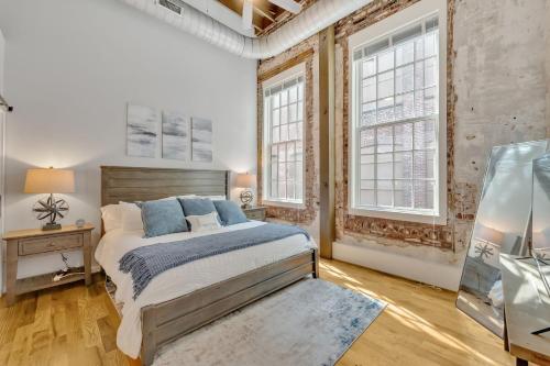 a bedroom with a bed and two windows at Heart of Downtown Knoxville in Knoxville