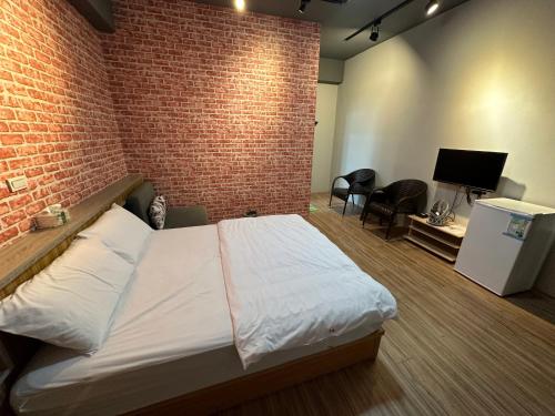 a bedroom with a bed and a brick wall at 丹藍民宿 in Magong