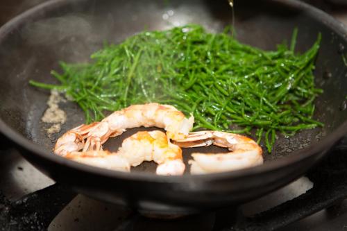 a pan with shrimp and green vegetables on a stove at Boutiquehotel Liebesglück - adults only in Winterberg