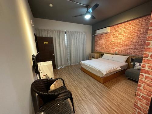 a bedroom with a bed and a brick wall at 丹藍民宿 in Magong