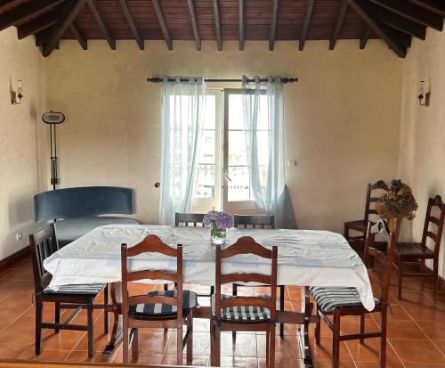 a dining room with a table and chairs and a window at Quinta do Sossego in Pico da Pedra