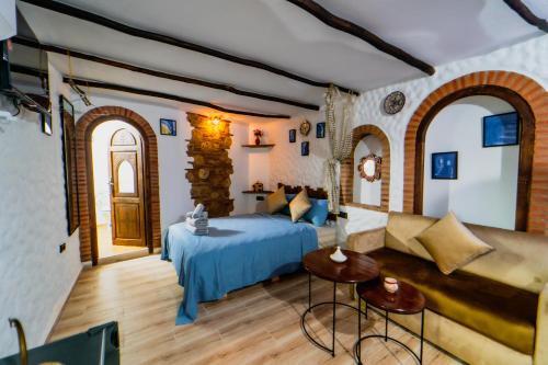 una camera da letto con un letto, un tavolo e delle sedie di Splendid traditioanal house in the main square a Chefchaouen