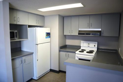 a kitchen with white cabinets and a white refrigerator at Toronto Metropolitan University-International Living Learning Residence in Toronto