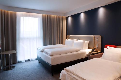 a hotel room with two beds and a window at Holiday Inn Express - Düsseldorf Airport in Düsseldorf