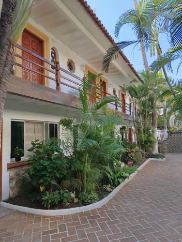a house with palm trees in front of it at Hotel Posada Pablo de Tarso in San Patricio Melaque