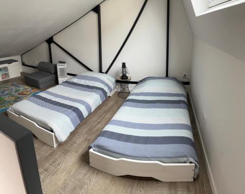 two twin beds in a room with at Loft relais Cœur de France in Vierzon