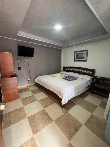 a bedroom with a bed and a tiled floor at Casa hotel villadiana in Armenia