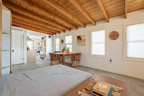a bedroom with a bed and a table and a kitchen at Historic 1900 Adobe Downtown Barrio Retreat in Tucson