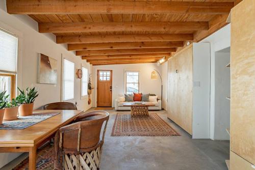 a living room with a wooden table and chairs at Historic 1900 Adobe Downtown Barrio Retreat in Tucson