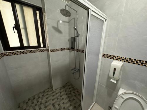 a bathroom with a shower stall and a toilet at 丹藍民宿 in Magong