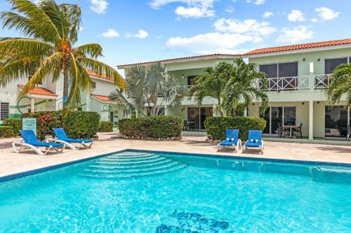 a swimming pool in front of a house with palm trees at Lagoon Ocean Resort in Lagun