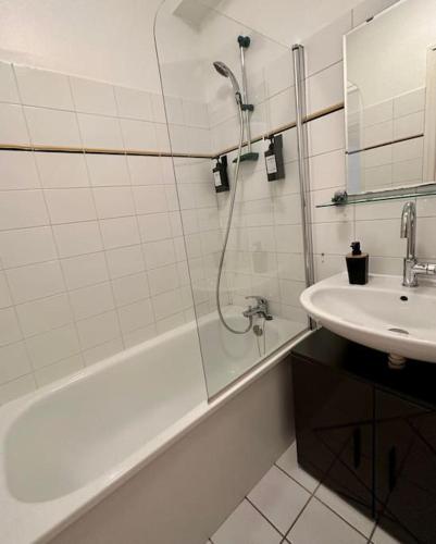 une salle de bain blanche avec une douche et un lavabo dans l'établissement Appartement neuf entièrement équipé proche centre, à Amiens