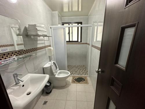 a bathroom with a toilet and a sink and a shower at 丹藍民宿 in Magong