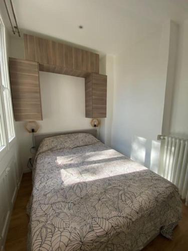 une chambre avec un lit dans une pièce dans l'établissement Appartement Colombes - 12min de PARIS, à Colombes