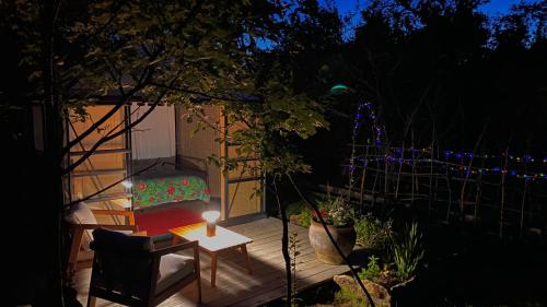 a room with a bed and a table with a candle at Le jardin secret in Semur-en-Auxois