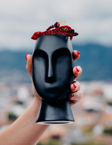 a hand holding a black mask with a face at Hotel Cruz del Vado by Art Hotels in Cuenca