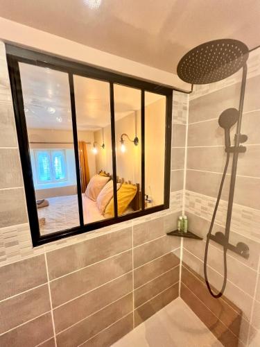 a bathroom with a shower and a bed in a mirror at Maison d'Hôtes Ty Belle in Saint-Guen
