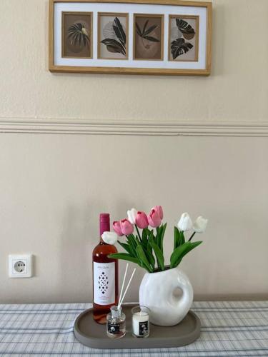 a table with a vase and a bottle of wine and flowers at Mary's Villa in Xanthi