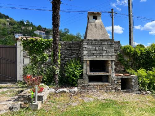 an outdoor oven in a yard with a stone wall at La Charmante in Le Vigan