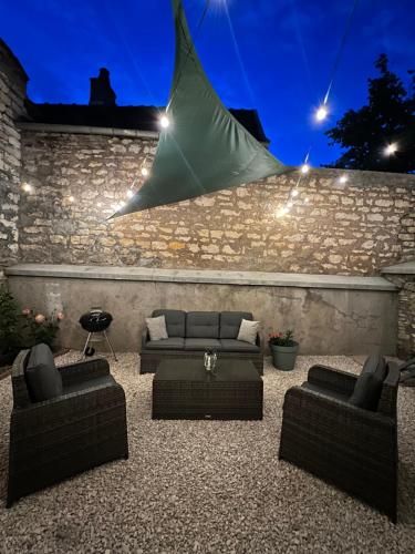 a living room with couches and a stone wall at Le Ptit Gite de Chablis - Maison avec Cour en Centre-Ville in Chablis