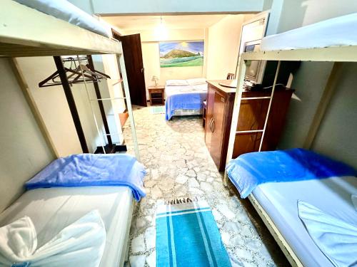 a room with two bunk beds and a desk at Hostel e Pousada Barra da Tijuca in Rio de Janeiro