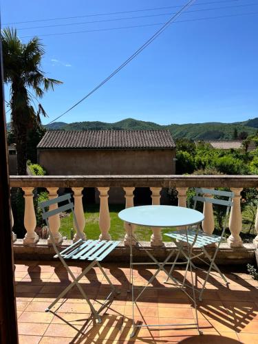 a white table on a balcony with a table at La Charmante in Le Vigan