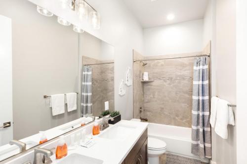 a white bathroom with a tub and a toilet and a sink at Ocotillo Springs Resort 45 l Brand New Property, Private Pool, Hot Tub, & Community Pool in Santa Clara