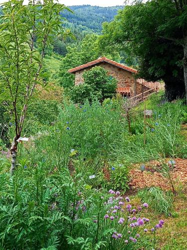a garden with flowers in front of a building at L'Abri-Gîte "Ô Jardin des Toiles" in Vaudevant