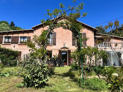 an archway in front of a house with a garden at La Charmante in Le Vigan