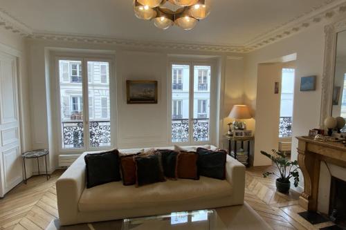 un salon avec un canapé et une cheminée dans l'établissement Cozy Haussmanian flat in the heart of Paris, à Paris