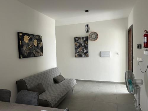 a living room with a couch and paintings on the wall at Penthouse no 8 in Il-Ħamra