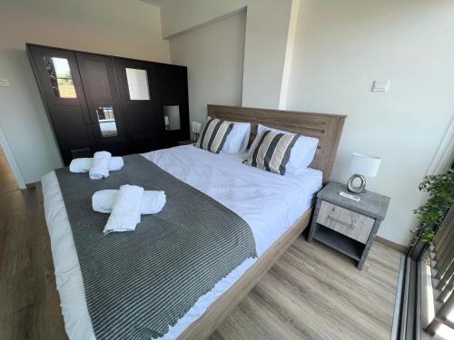 Un dormitorio con una cama grande con toallas. en Azul sea view, en Lárnaca