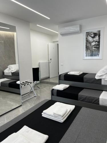 a room with two beds and a mirror at White Elegance Luxury B&B Caserta in Caserta