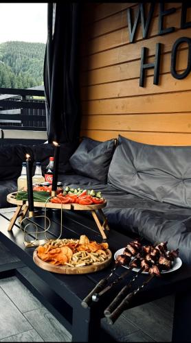 two plates of food on a table next to a bed at Weekend house in Verkhovyna