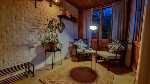a room with a table and chairs and a brick wall at Moja Vila Bled in Bled