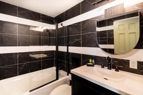 a black and white bathroom with a sink and a mirror at Spokane Club Hotel in Spokane