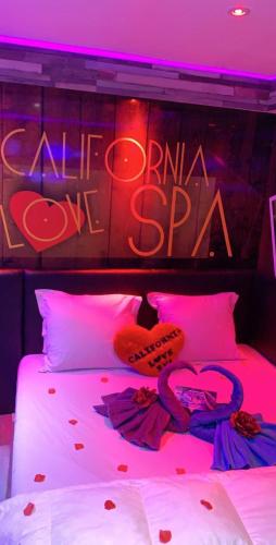 Cette chambre comprend un lit avec un panneau de néon. dans l'établissement California love spa, à Lille