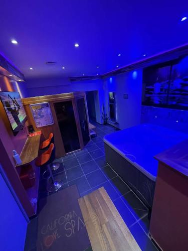 une chambre bleue avec une grande baignoire et un bar dans l'établissement California love spa, à Lille