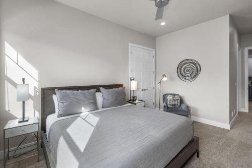 a white bedroom with a large bed and a chair at Ocotillo Springs 67 Low Prices, Private Hot Tub, Pool, Basketball Arcade, Ping Pong and Community Pool in Santa Clara