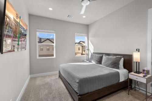 a white bedroom with a bed and two windows at Ocotillo Springs 67 Low Prices, Private Hot Tub, Pool, Basketball Arcade, Ping Pong and Community Pool in Santa Clara