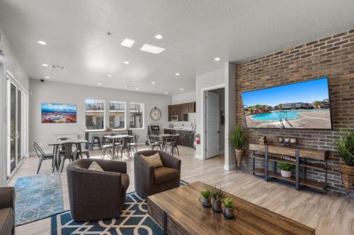 a living room with a large tv on a brick wall at Ocotillo Springs 67 Low Prices, Private Hot Tub, Pool, Basketball Arcade, Ping Pong and Community Pool in Santa Clara