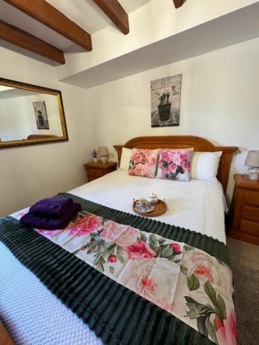 a bedroom with a bed with a floral bedspread at Casa Turistica Torreón de Villafamés in Villafamés
