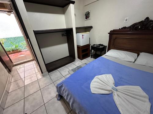 a bedroom with a blue bed with a bow on it at Hostel e Pousada Barra da Tijuca in Rio de Janeiro