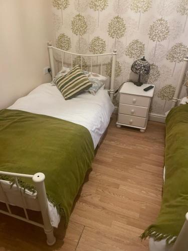 a bedroom with a white bed and a night stand at Dolphin Inn in Llanymynech