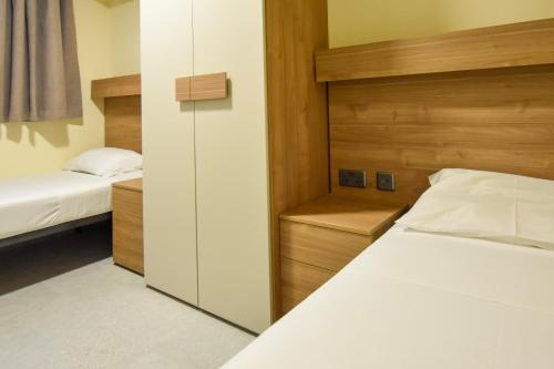 a small bedroom with two beds and a closet at 51HH Apartments in Il-Gżira