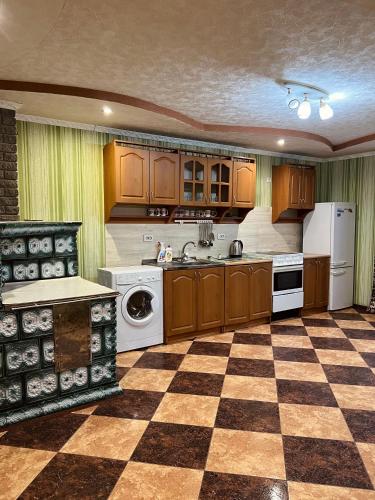 a kitchen with wooden cabinets and a checkered floor at Садиба Файна Гофа in Verkhovyna